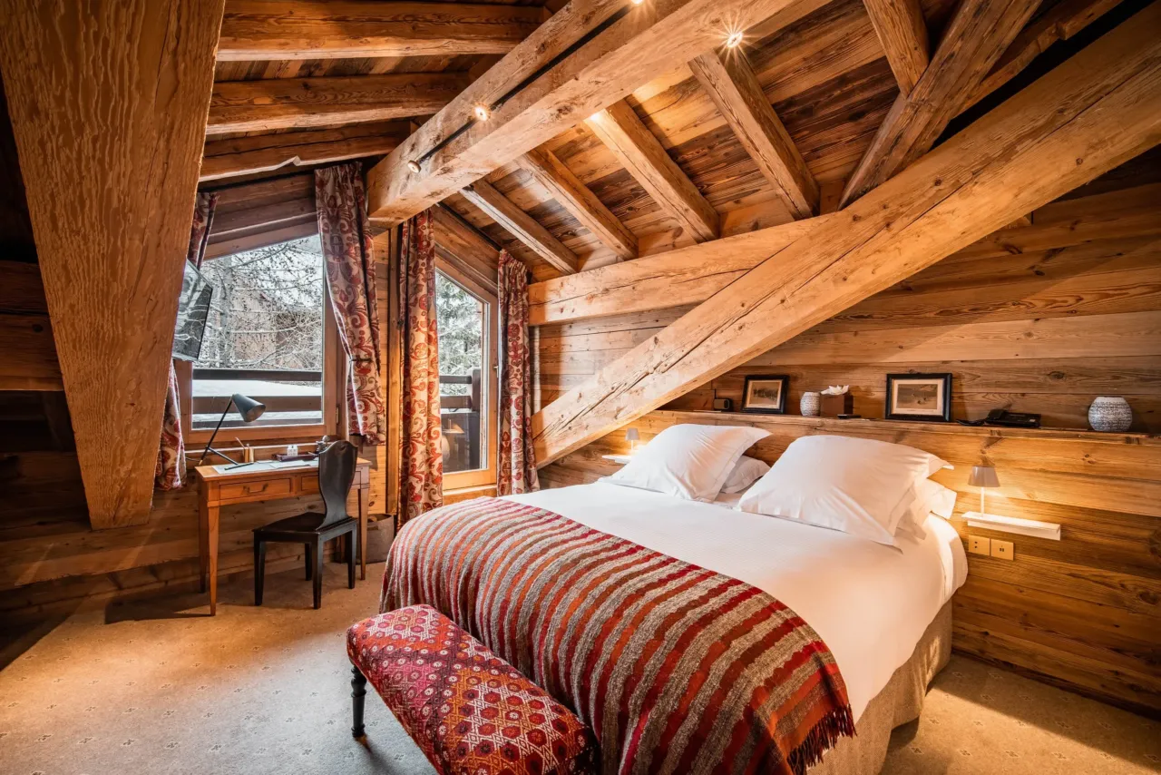 Chambre rustique avec lit double et bureau en bois&nbsp;dans&nbsp;un chalet&nbsp;&agrave; Val d&rsquo;Is&egrave;re, H&ocirc;tel Village La Mourra.