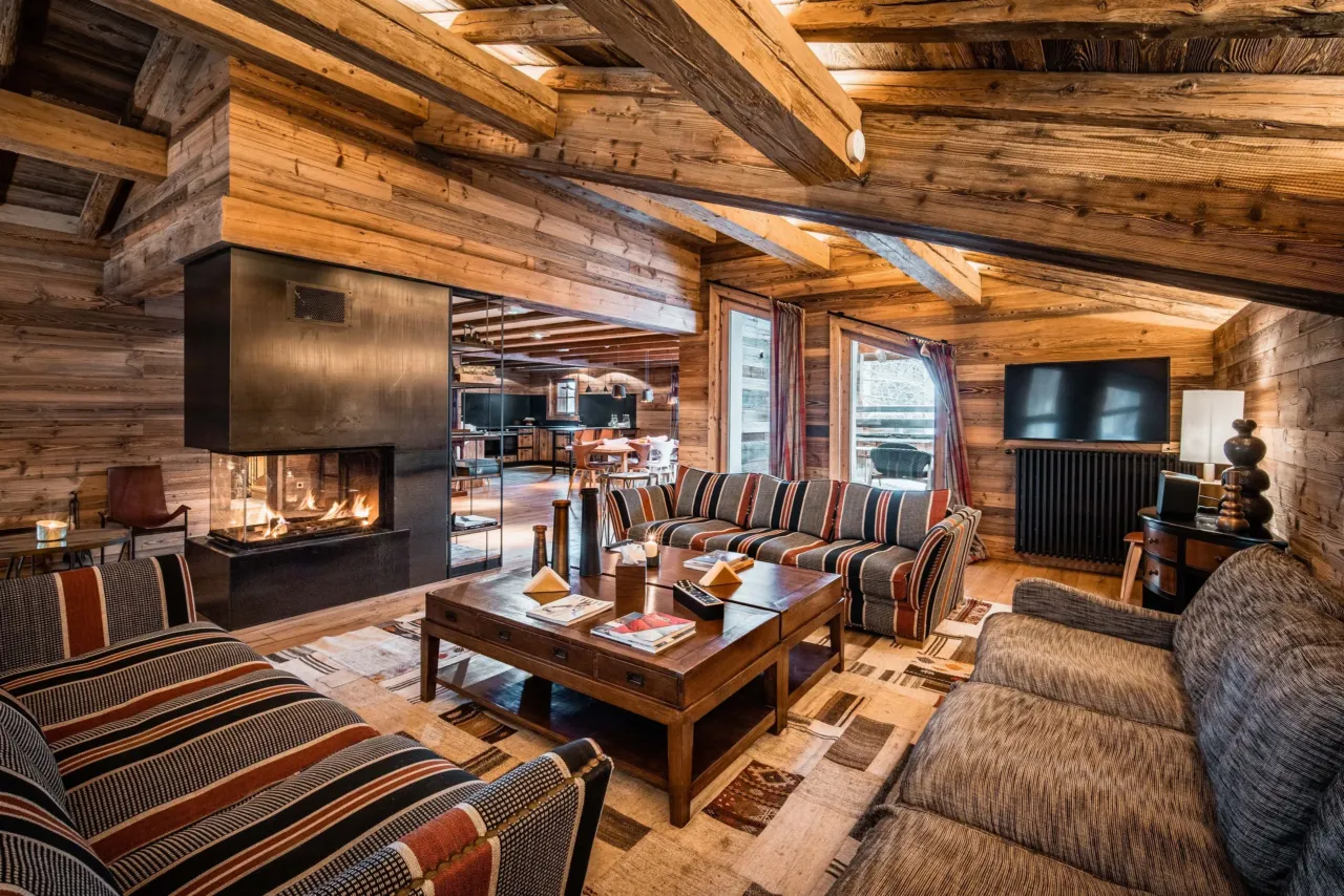 Salon chalet en bois avec chemin&eacute;e moderne&nbsp;dans&nbsp;un chalet&nbsp;&agrave; Val d&rsquo;Is&egrave;re, H&ocirc;tel Village La Mourra.