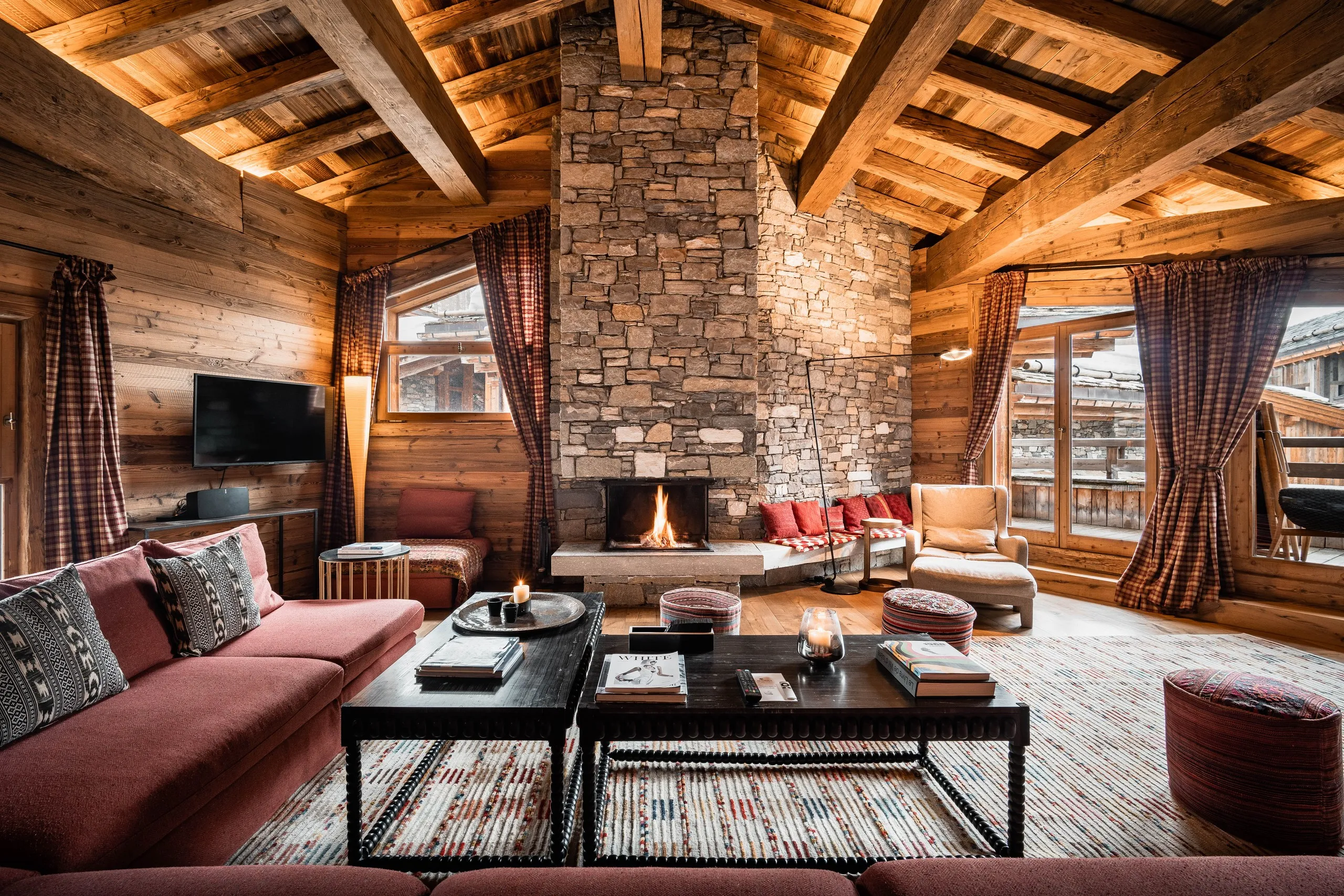 Salon chalet chaleureux avec chemin&eacute;e en pierre, dans&nbsp;un chalet&nbsp;&agrave; Val d&rsquo;Is&egrave;re, H&ocirc;tel Village La Mourra.