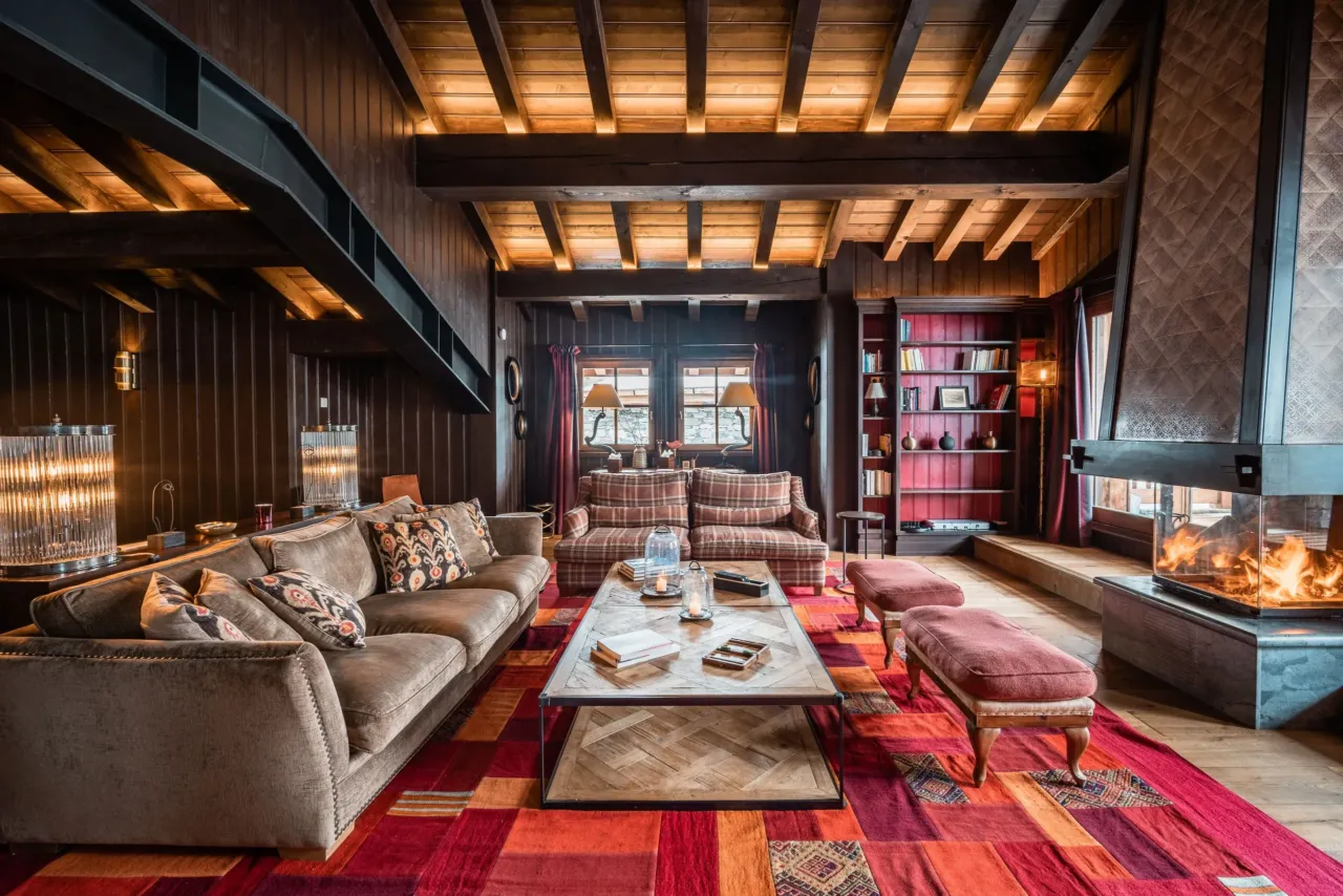 Salon confortable avec chemin&eacute;e et biblioth&egrave;que, dans&nbsp;un chalet&nbsp;&agrave; Val d&rsquo;Is&egrave;re, H&ocirc;tel Village La Mourra.