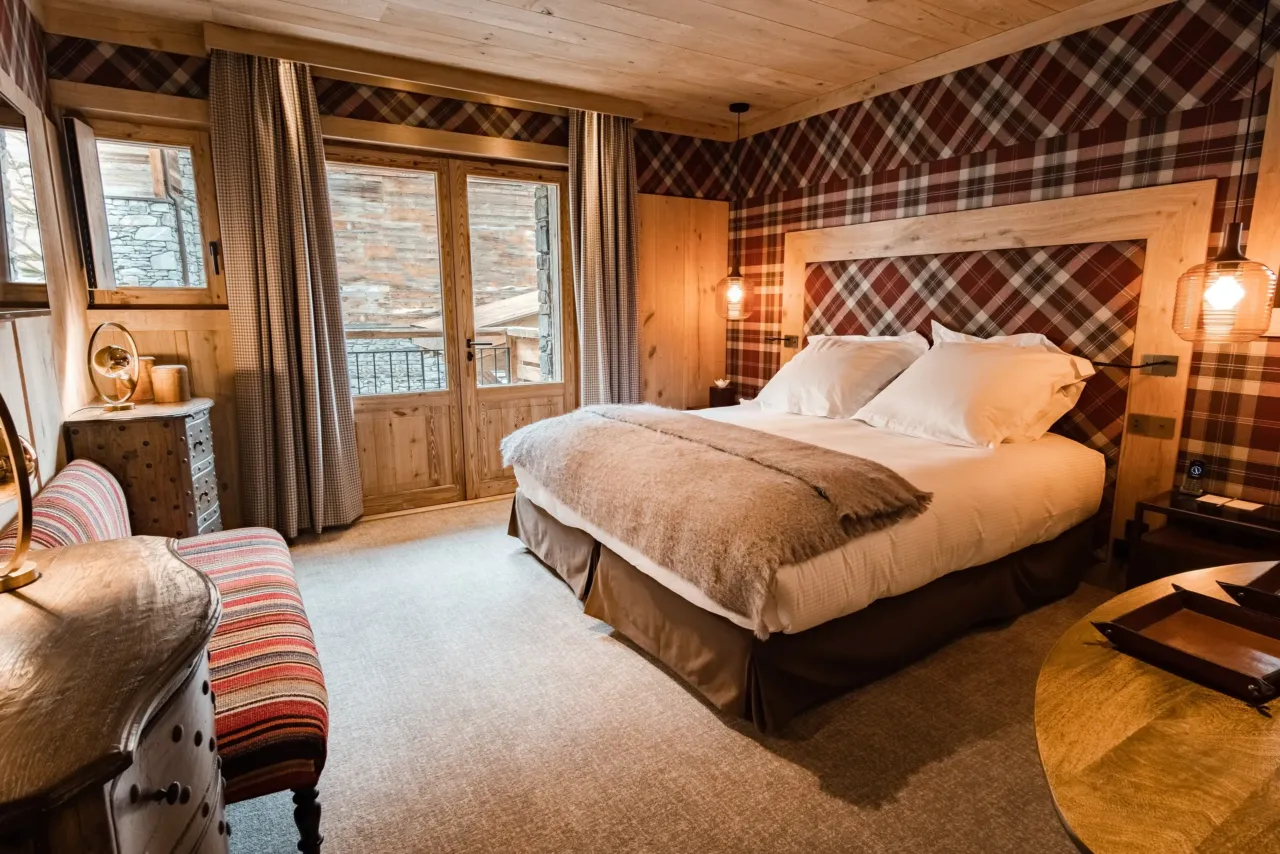 Chambre rustique avec lit double et d&eacute;cor chaleureux, dans&nbsp;un chalet&nbsp;&agrave; Val d&rsquo;Is&egrave;re, H&ocirc;tel Village La Mourra.