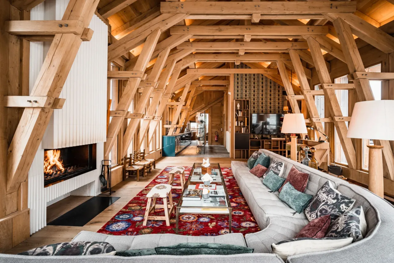 Int&eacute;rieur chalet avec chemin&eacute;e et canap&eacute;, dans&nbsp;un chalet&nbsp;&agrave; Val d&rsquo;Is&egrave;re, H&ocirc;tel Village La Mourra.