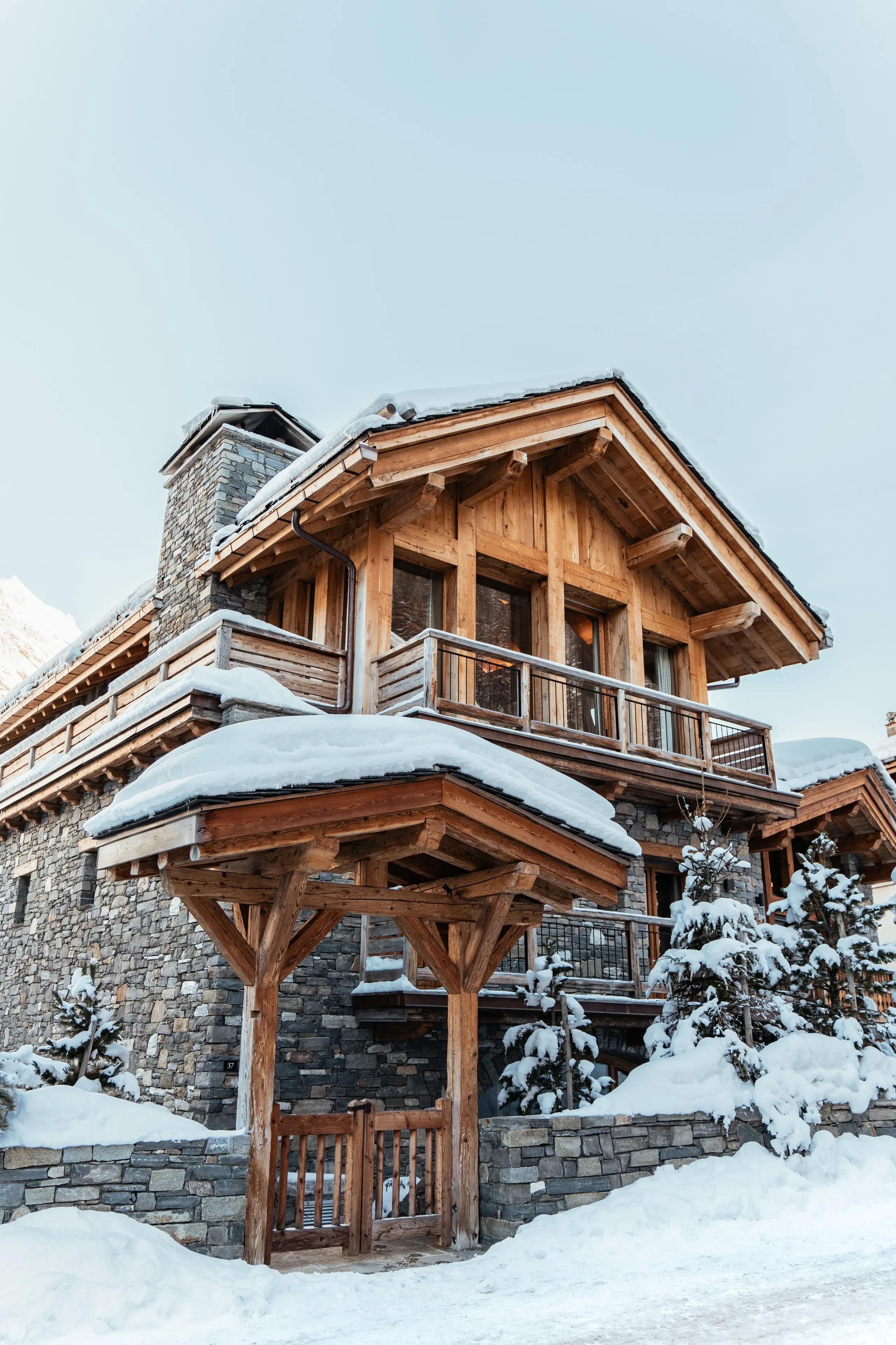 Chalet de montagne enneigé avec balcon en bois, dans un chalet à Val d’Isère, Hôtel Village La Mourra.
