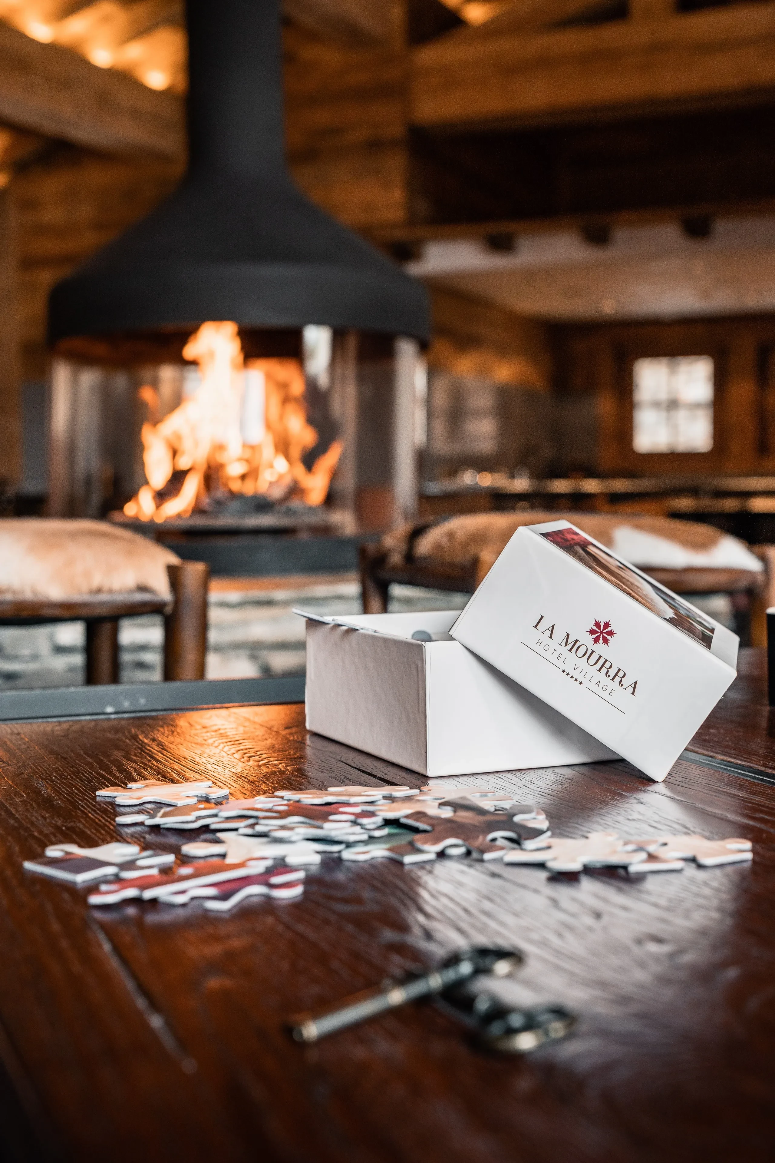 Boîte de puzzle près d'une cheminée allumée, dans un chalet à Val d’Isère, Hôtel Village La Mourra.